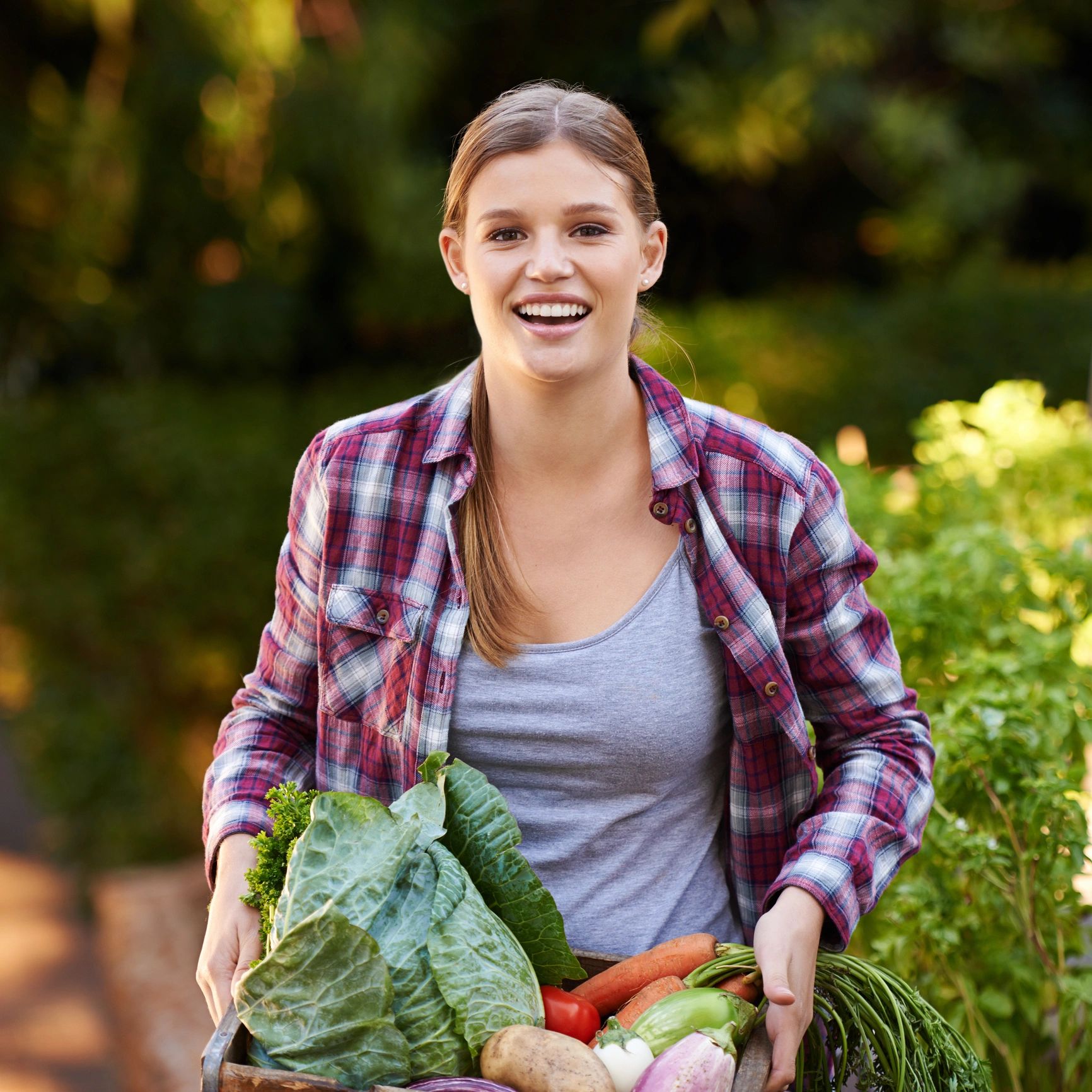 Team member holding a crate of freshly picked vegetables